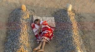 الطفل السوري الراقد بين قبري والديه